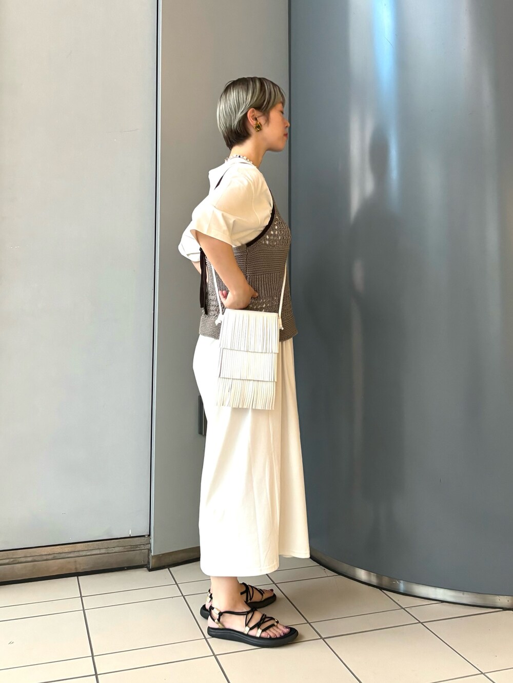 グレー系のキャミソール、グレー系のワンピース、ホワイト系のショルダーバッグを着用したレディースの夏コーディネートの2枚目の写真