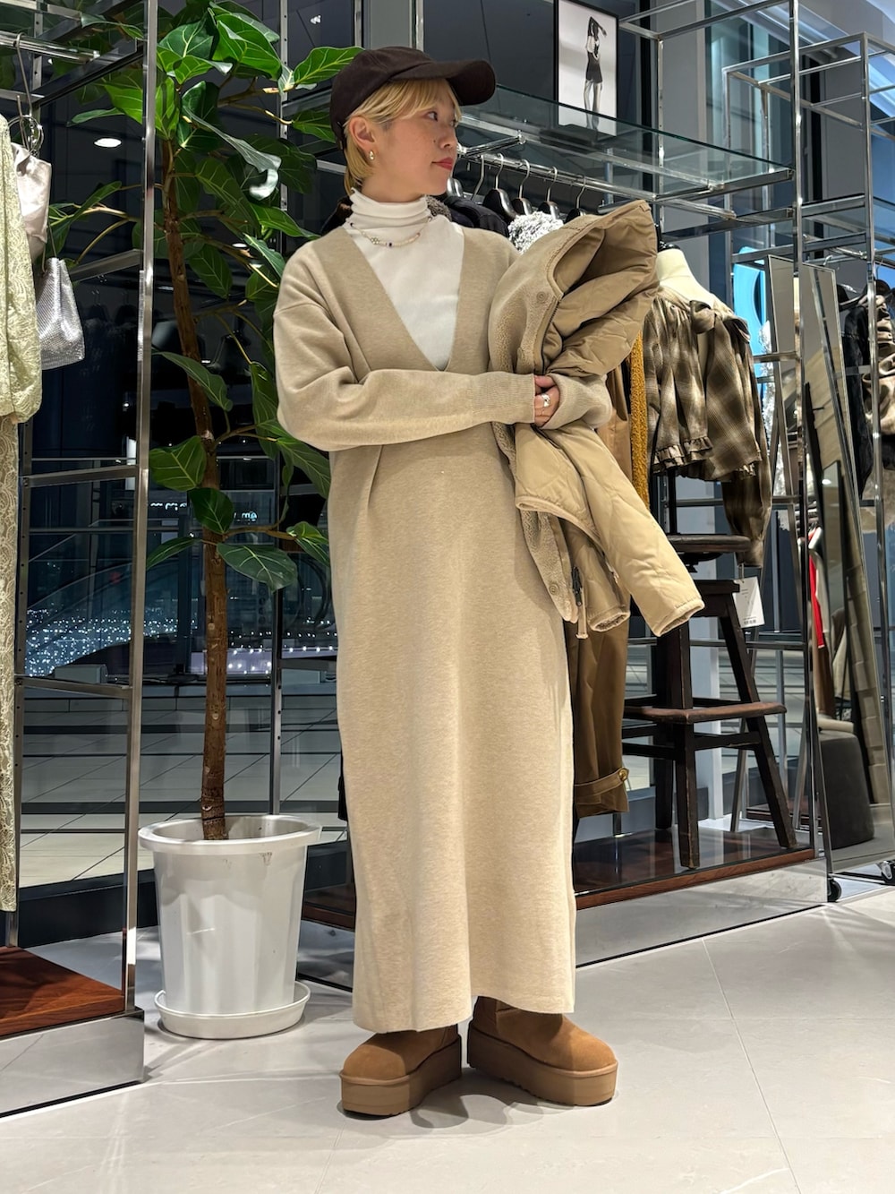 ホワイト系のTシャツ/カットソー、ベージュ系のダウンジャケット/コート、ブラウン系のブーツを着用したレディースの秋コーディネートの4枚目の写真