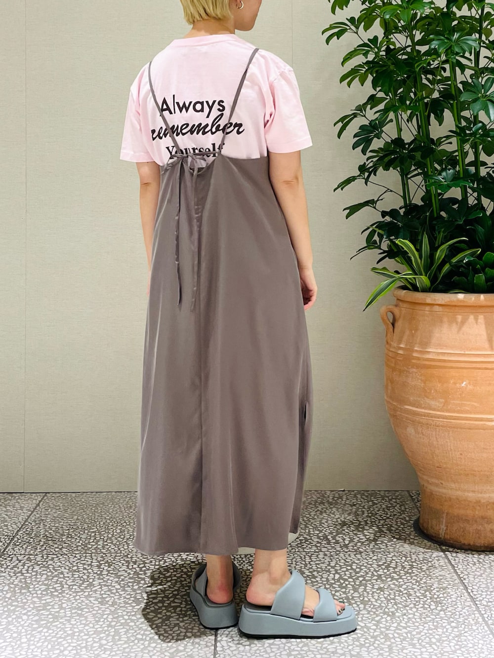 ピンク系のTシャツ/カットソー、ブラウン系のワンピース、ブルー系のサンダルを着用したレディースの春コーディネートの3枚目の写真