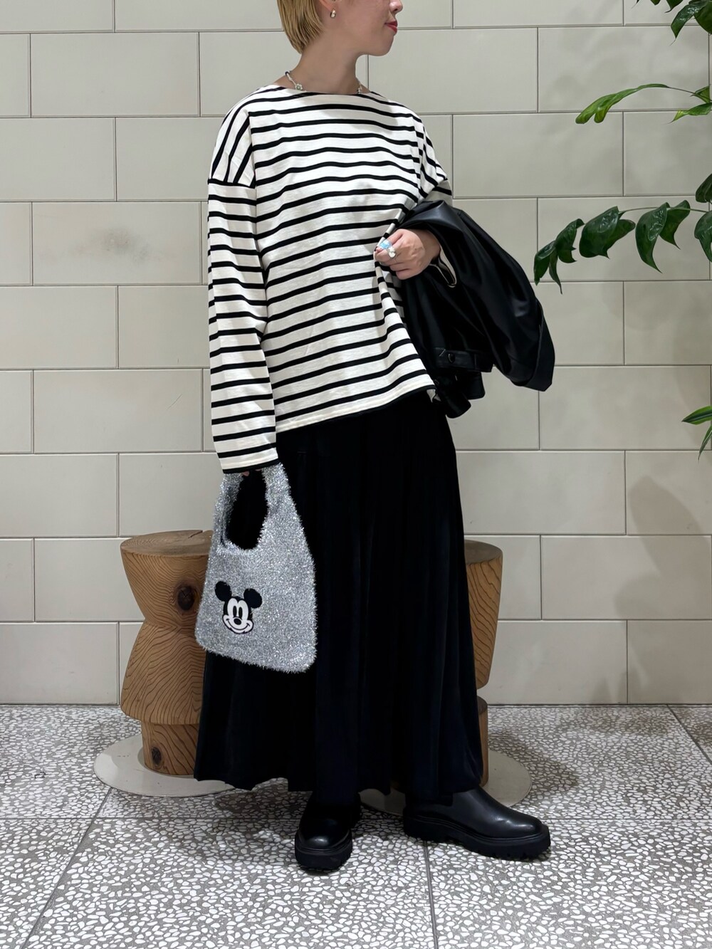 ブラック系のブルゾン、ホワイト系のTシャツ/カットソー、ブラック系のスカートを着用したレディースの秋コーディネートの2枚目の写真