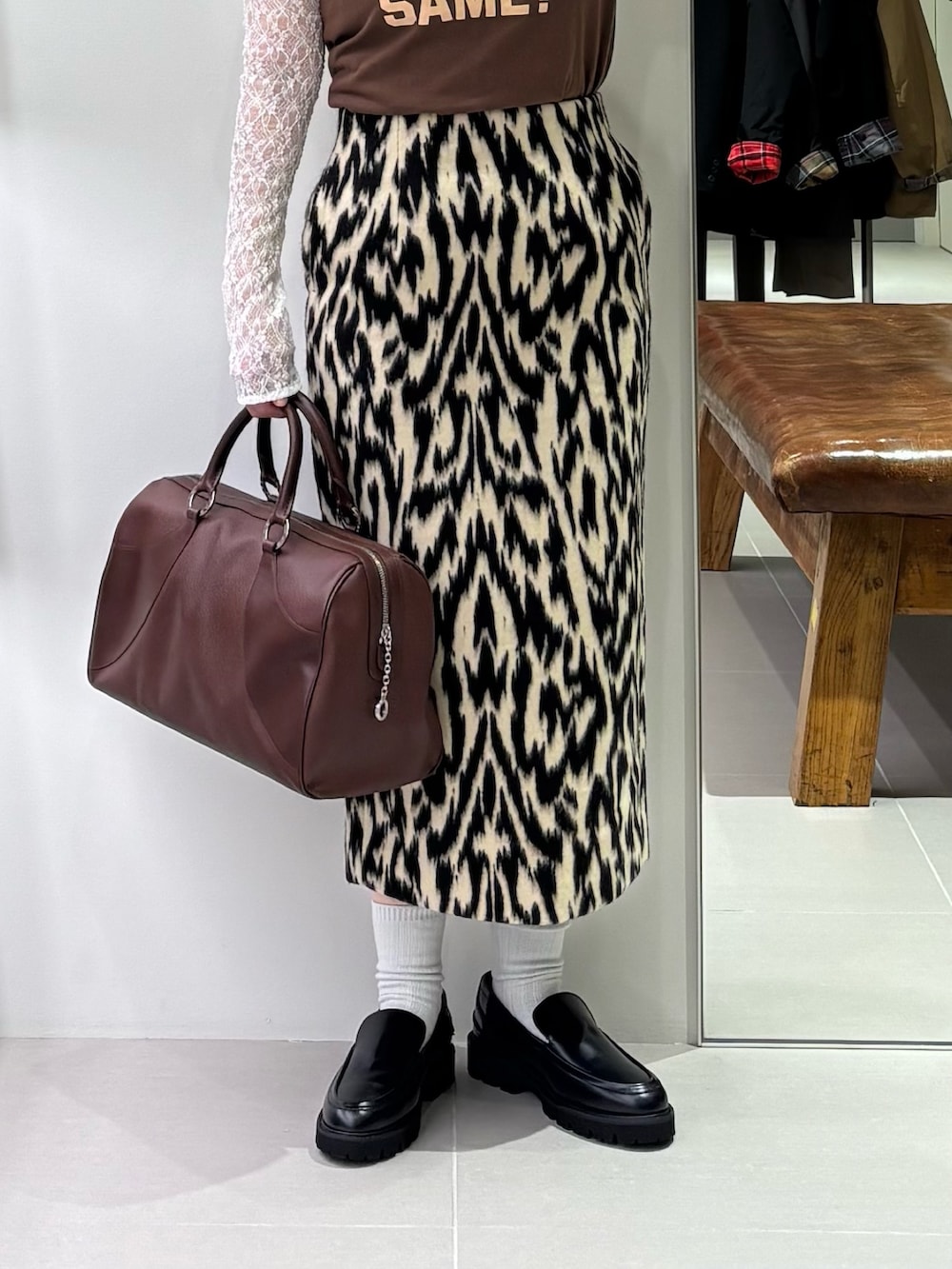 ブラウン系のTシャツ/カットソー、ホワイト系のTシャツ/カットソー、ブラック系のローファーを着用したレディースの秋コーディネートの3枚目の写真