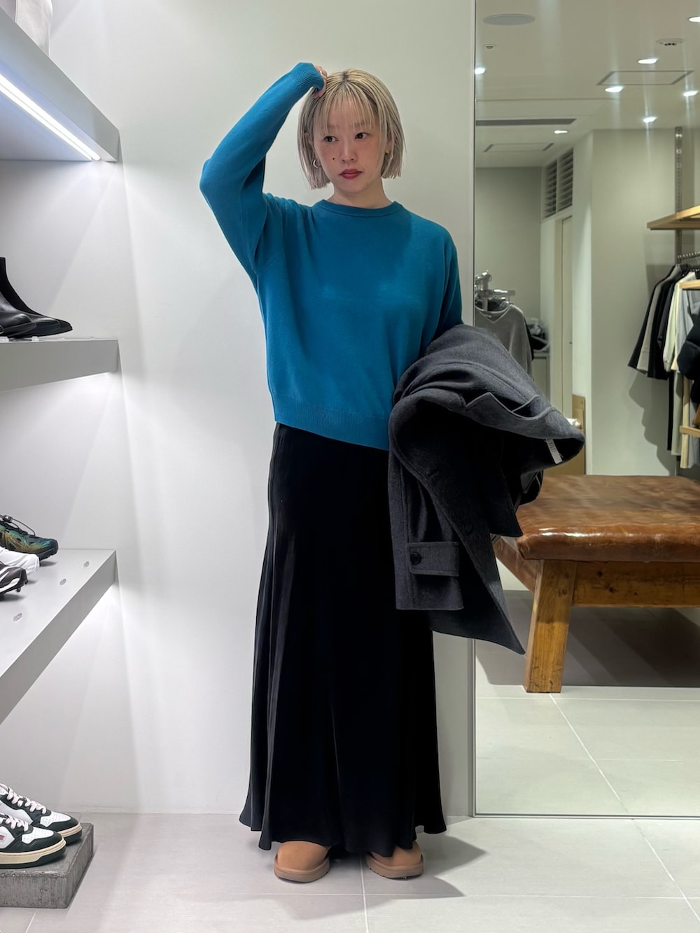 グレー系のピーコート、ブルー系のニット/セーター、ブラック系のショルダーバッグを着用したレディースの秋コーディネートの5枚目の写真