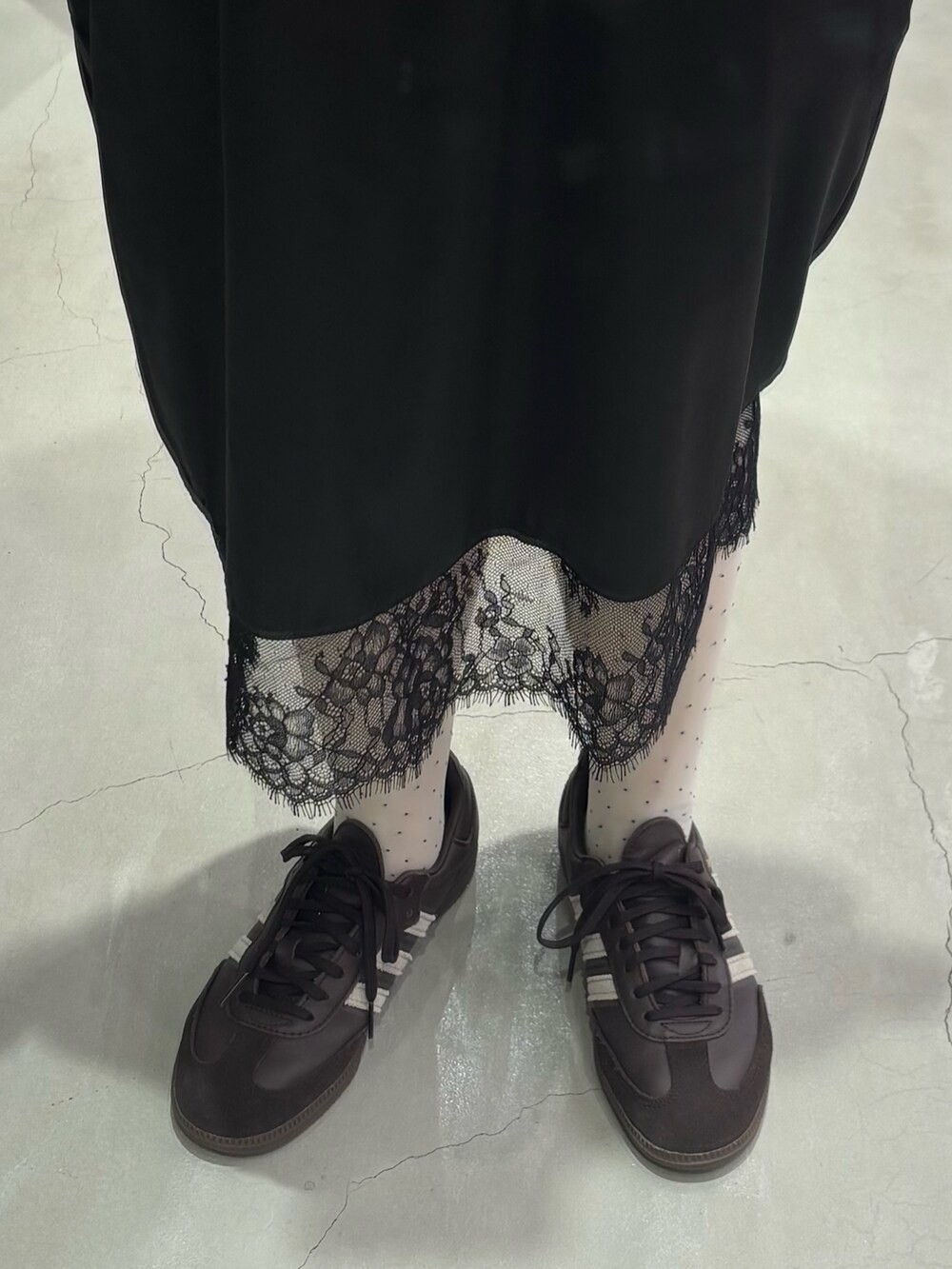 レッド系のニット/セーター、ブラウン系のスニーカー、ホワイト系のその他アンダーウェア/インナーを着用したレディースの秋コーディネートの3枚目の写真