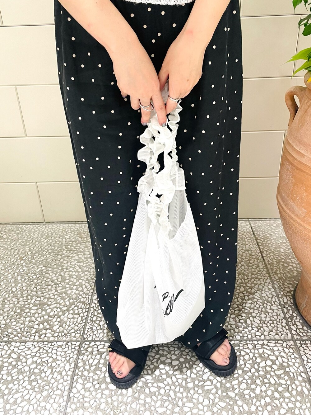 ホワイト系のニット/セーター、ブラック系のその他パンツ、ホワイト系のトートバッグを着用したレディースの春コーディネートの4枚目の写真