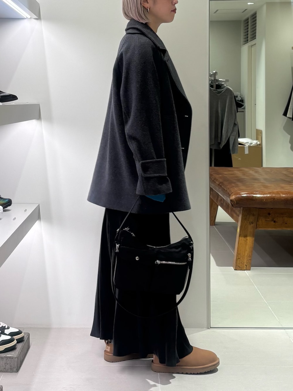 グレー系のピーコート、ブルー系のニット/セーター、ブラック系のショルダーバッグを着用したレディースの秋コーディネートの3枚目の写真