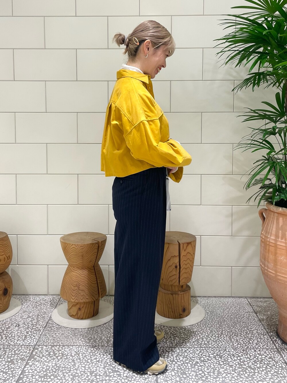 ホワイト系のTシャツ/カットソー、イエロー系のシャツ/ブラウス、グリーン系のスニーカーを着用したレディースの冬コーディネートの2枚目の写真