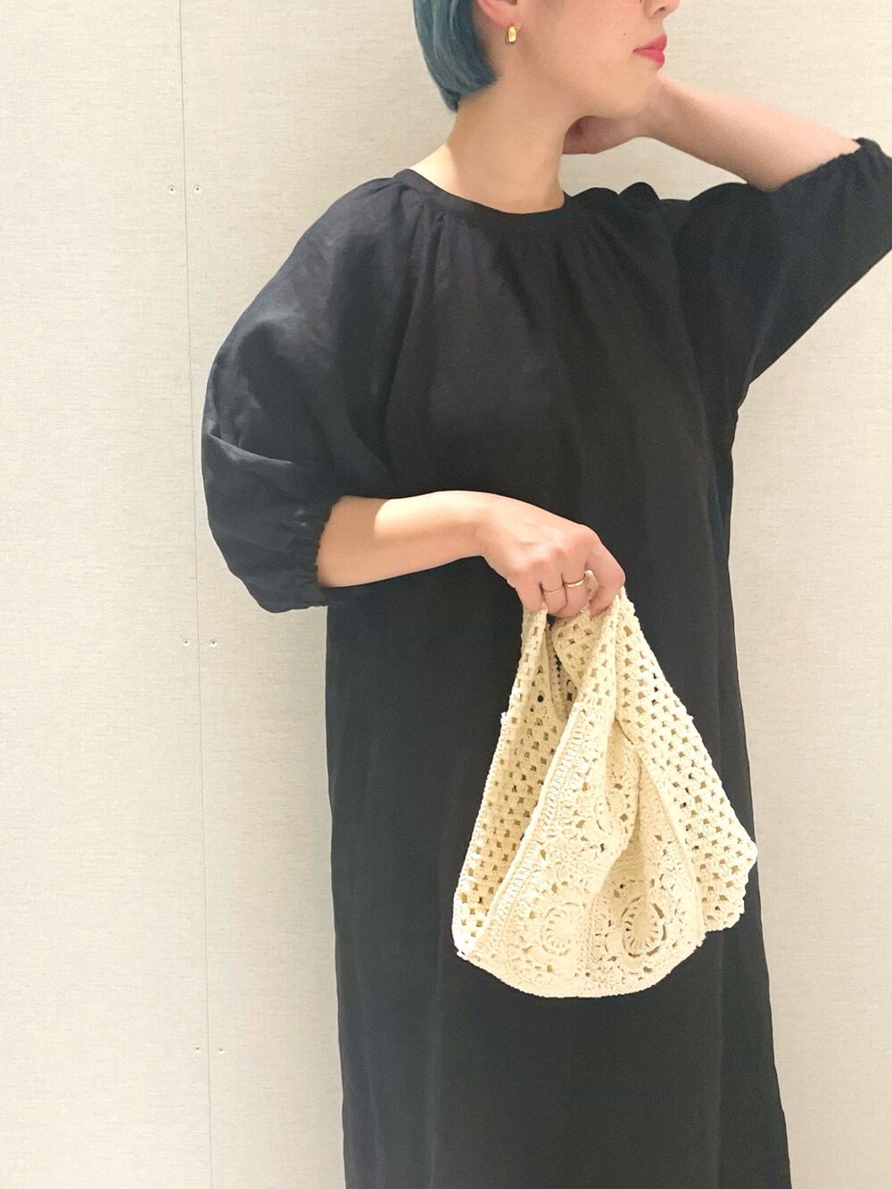 ブラック系のワンピース、ホワイト系のショルダーバッグ、グレー系のスニーカーを着用したレディースの春コーディネートの3枚目の写真