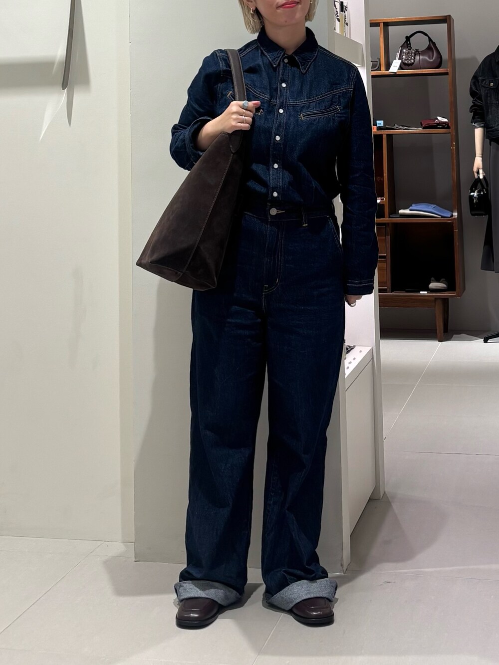 ブルー系のサロペット/オーバーオール、ブラウン系のトートバッグ、ブラウン系のローファーを着用したレディースの秋コーディネートの3枚目の写真