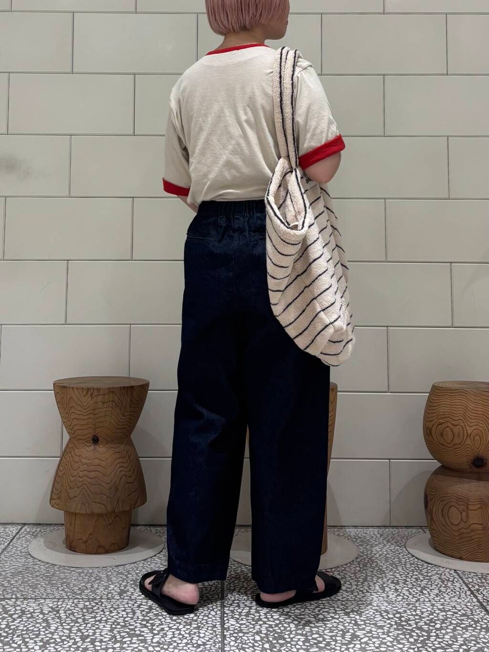 ブルー系のデニムパンツ、ブラック系のサンダル、レッド系のTシャツ/カットソーを着用したレディースの春コーディネートの3枚目の写真