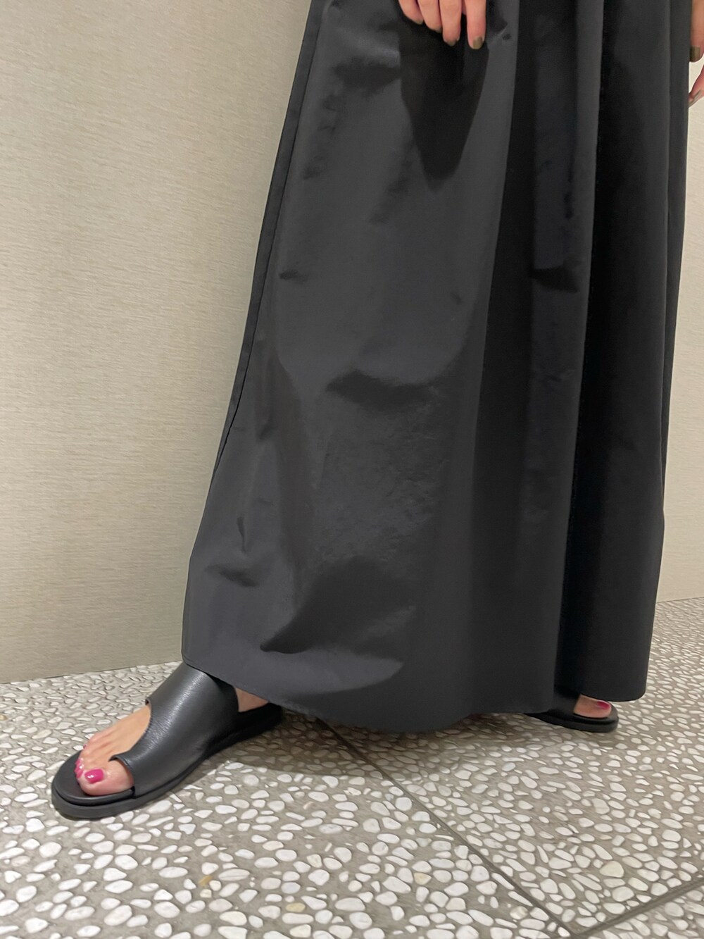 ブラック系のスカート、ブラック系のサンダル、レッド系のTシャツ/カットソーを着用したレディースの春コーディネートの4枚目の写真