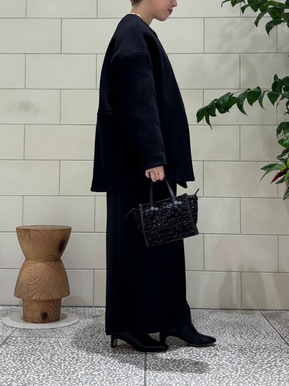 ブラック系のその他アウター、ブラック系のハンドバッグ、ブラック系のシャツ/ブラウスを着用したレディースの冬コーディネートの2枚目の写真