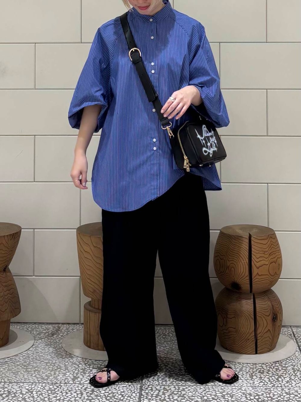 ブラック系のその他パンツ、ブラック系のショルダーバッグ、ブルー系のシャツ/ブラウスを着用したレディースの春コーディネートの2枚目の写真