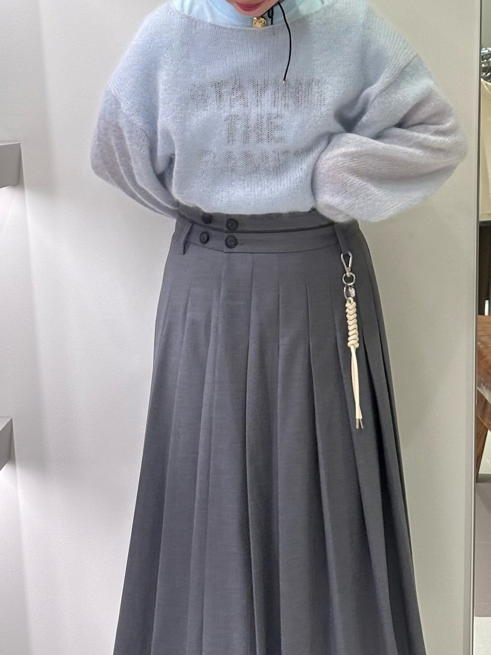 ブルー系のニット/セーター、ブルー系のTシャツ/カットソー、グリーン系のスカートを着用したレディースの秋コーディネートの3枚目の写真