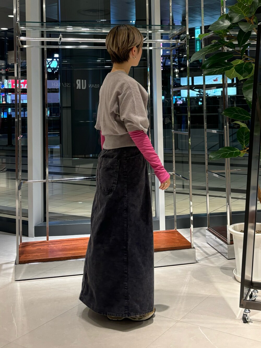 ピンク系のTシャツ/カットソー、ブルー系のスカート、ホワイト系のスニーカーを着用したレディースの秋コーディネートの2枚目の写真