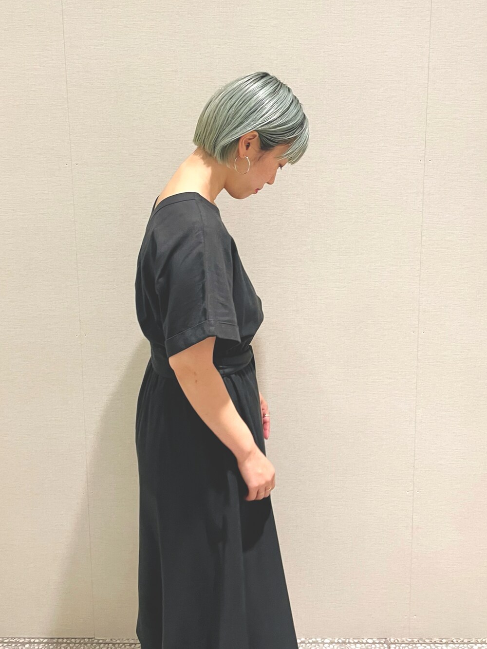 グレー系のワンピース、グリーン系のサンダル、シルバー系のピアス（両耳用）を着用したレディースの夏コーディネートの4枚目の写真