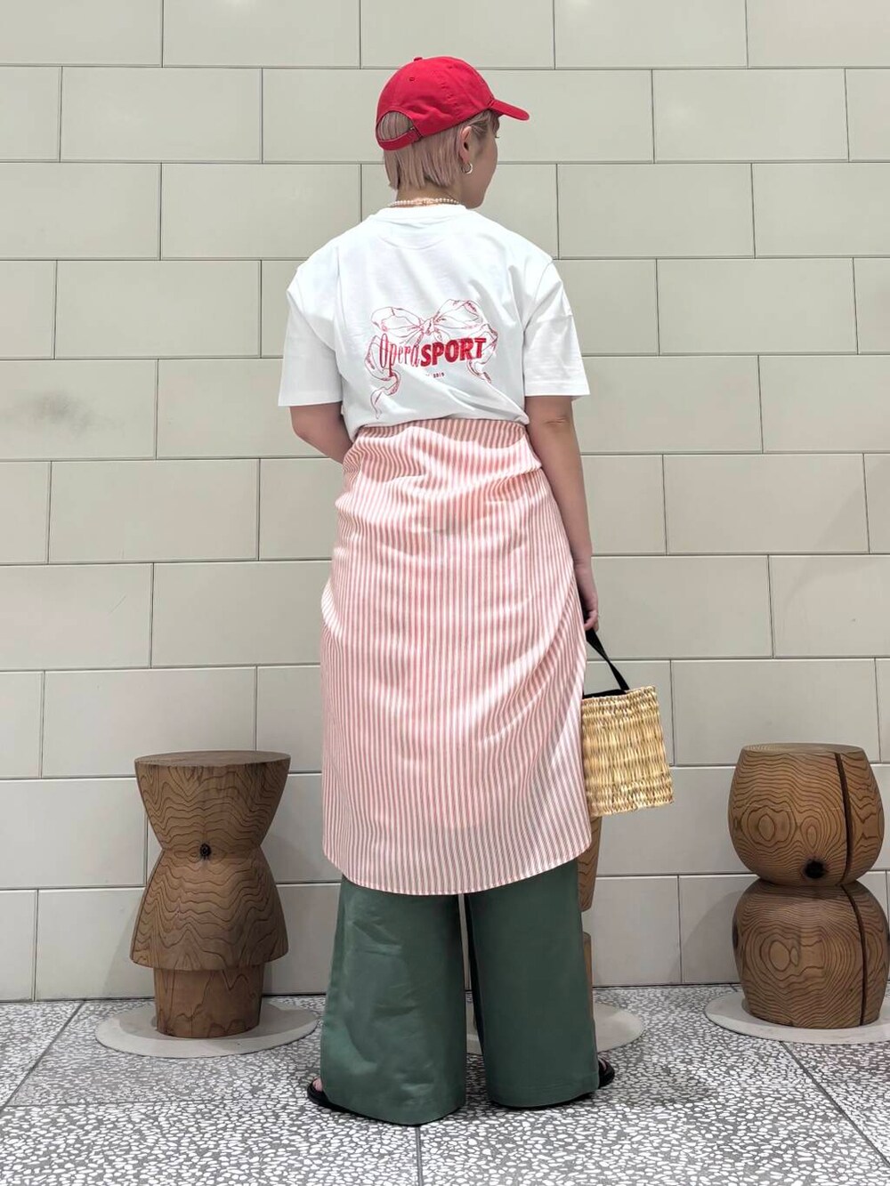 グリーン系のその他パンツ、ブラック系のかごバッグ、ブラック系のサンダルを着用したレディースの夏コーディネートの3枚目の写真