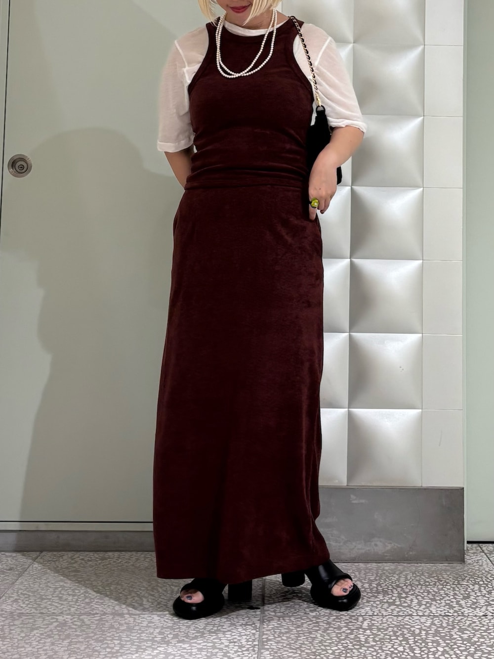 ホワイト系のTシャツ/カットソー、ブラック系のハンドバッグ、ブラウン系のスカートを着用したレディースの夏コーディネートの3枚目の写真