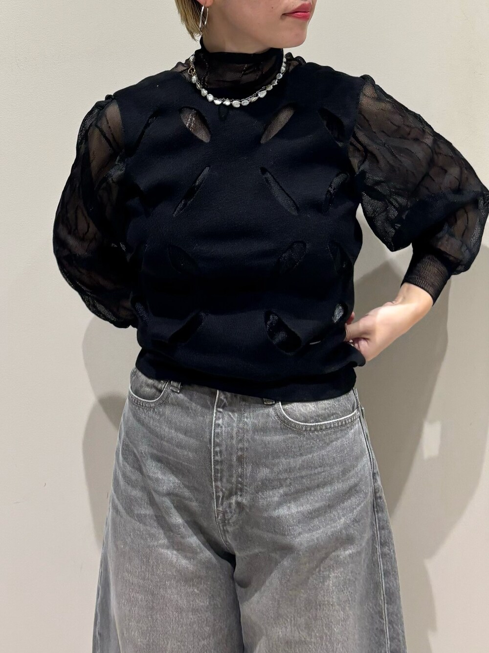 ブラック系のトップス、ブラック系のトップス、グリーン系のデニムパンツを着用したレディースの秋コーディネートの2枚目の写真