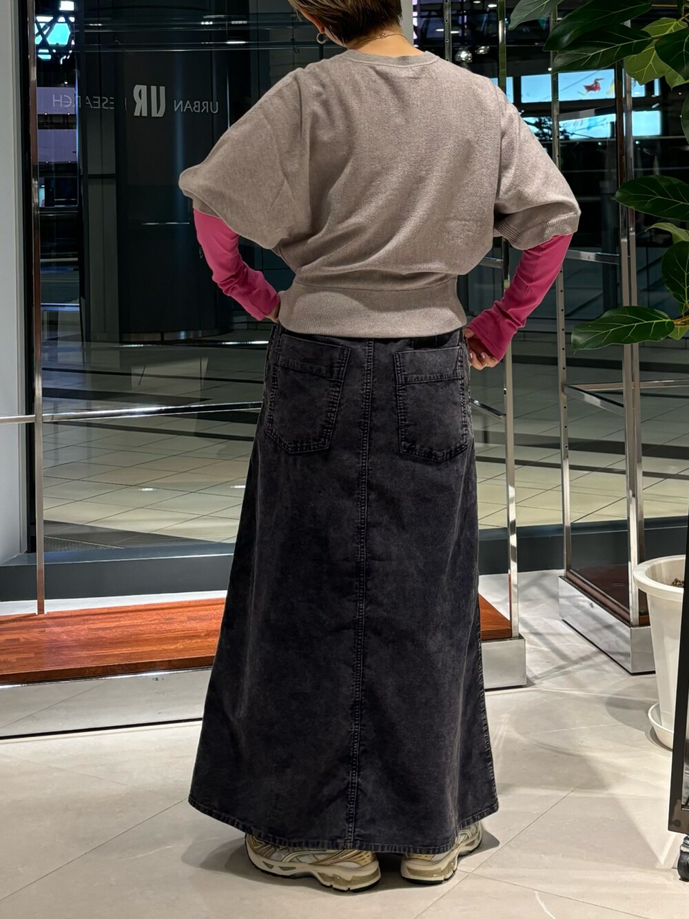 ピンク系のTシャツ/カットソー、ブルー系のスカート、ホワイト系のスニーカーを着用したレディースの秋コーディネートの3枚目の写真