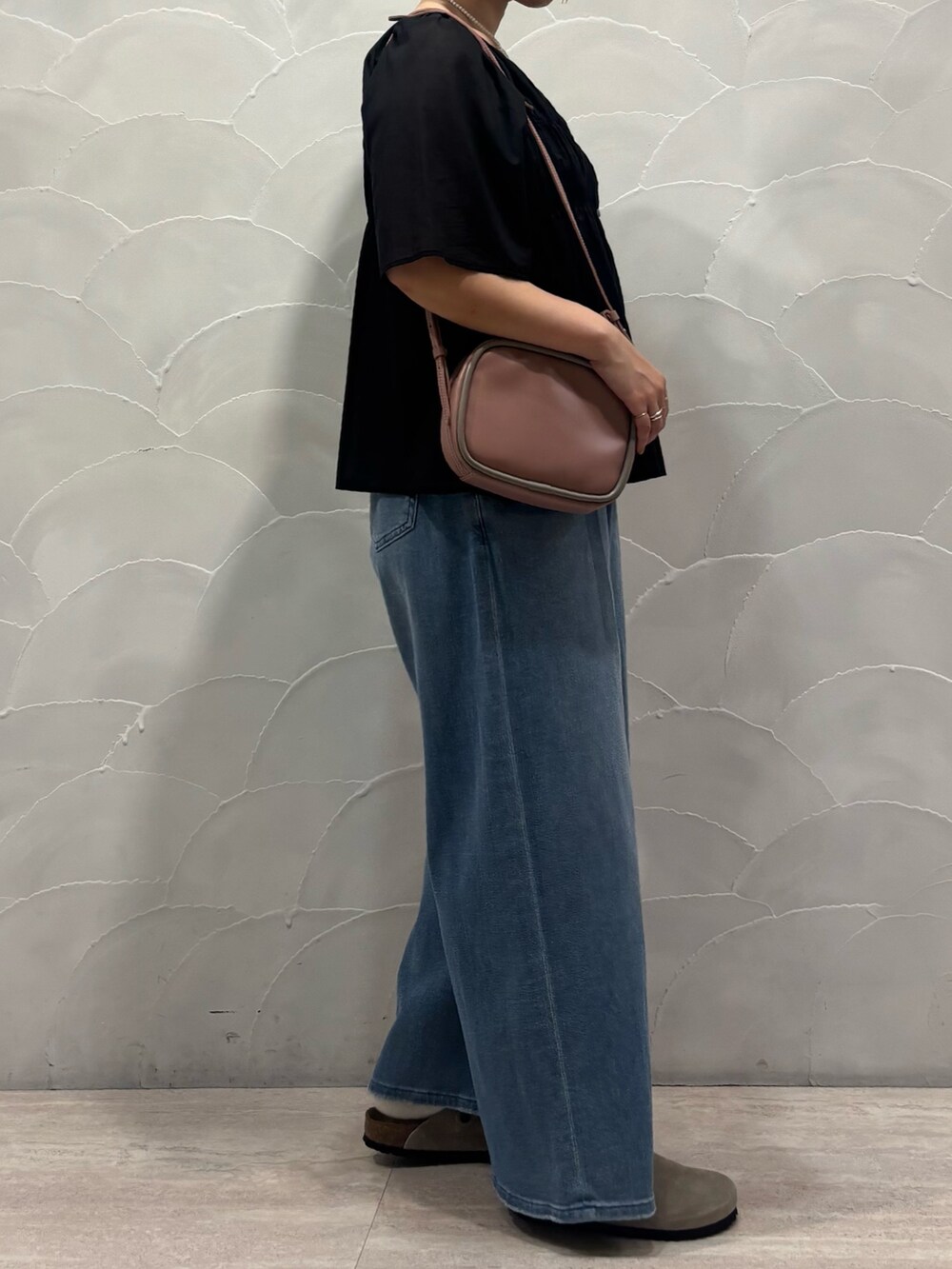 ピンク系のショルダーバッグ、ブルー系のデニムパンツ、ブラック系のシャツ/ブラウスを着用したレディースの夏コーディネートの2枚目の写真