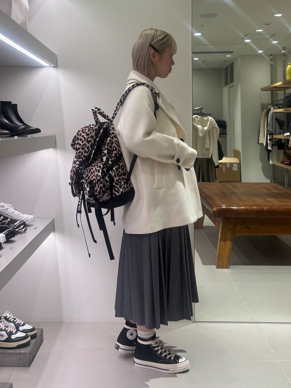 ホワイト系のピーコート、ホワイト系のニット/セーター、グリーン系のスカートを着用したレディースの冬コーディネートの2枚目の写真