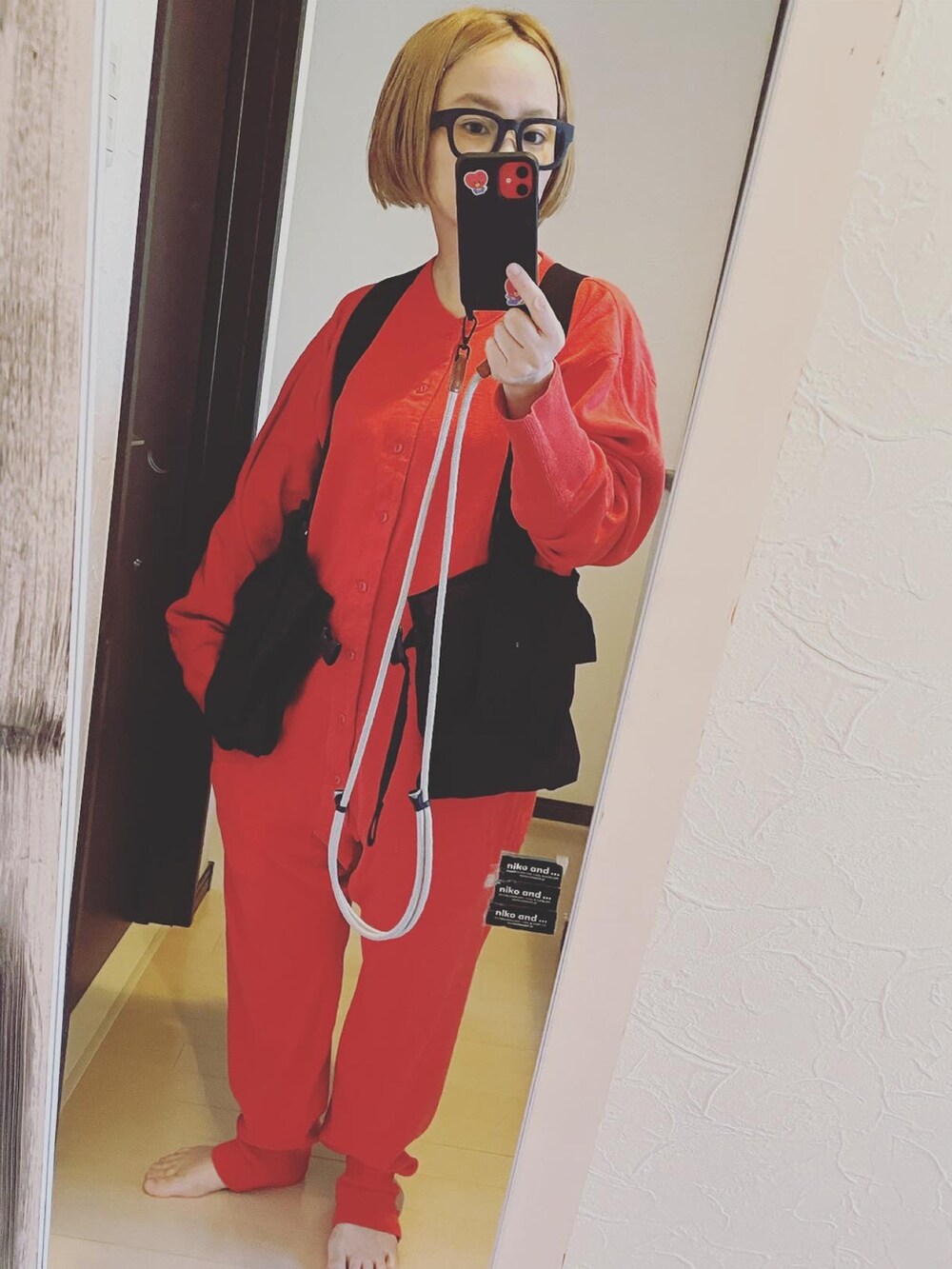 レッド系のオールインワン・サロペット、ブラック系のベストを着用したレディースの秋コーディネートの2枚目の写真