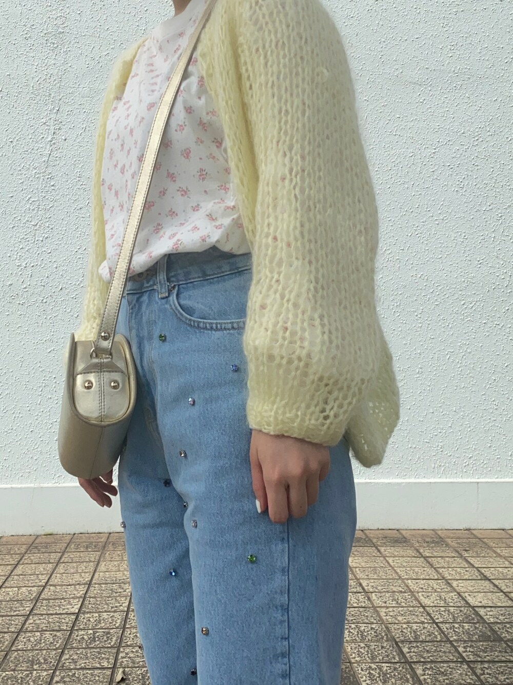ブルー系のデニムパンツ、ゴールド系のその他シューズ、ゴールド系のショルダーバッグを着用したレディースの春コーディネートの2枚目の写真