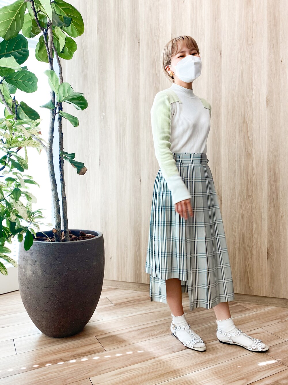 ホワイト系のサンダル、ホワイト系のニット/セーター、グリーン系のスカートを着用したレディースの秋コーディネートの2枚目の写真