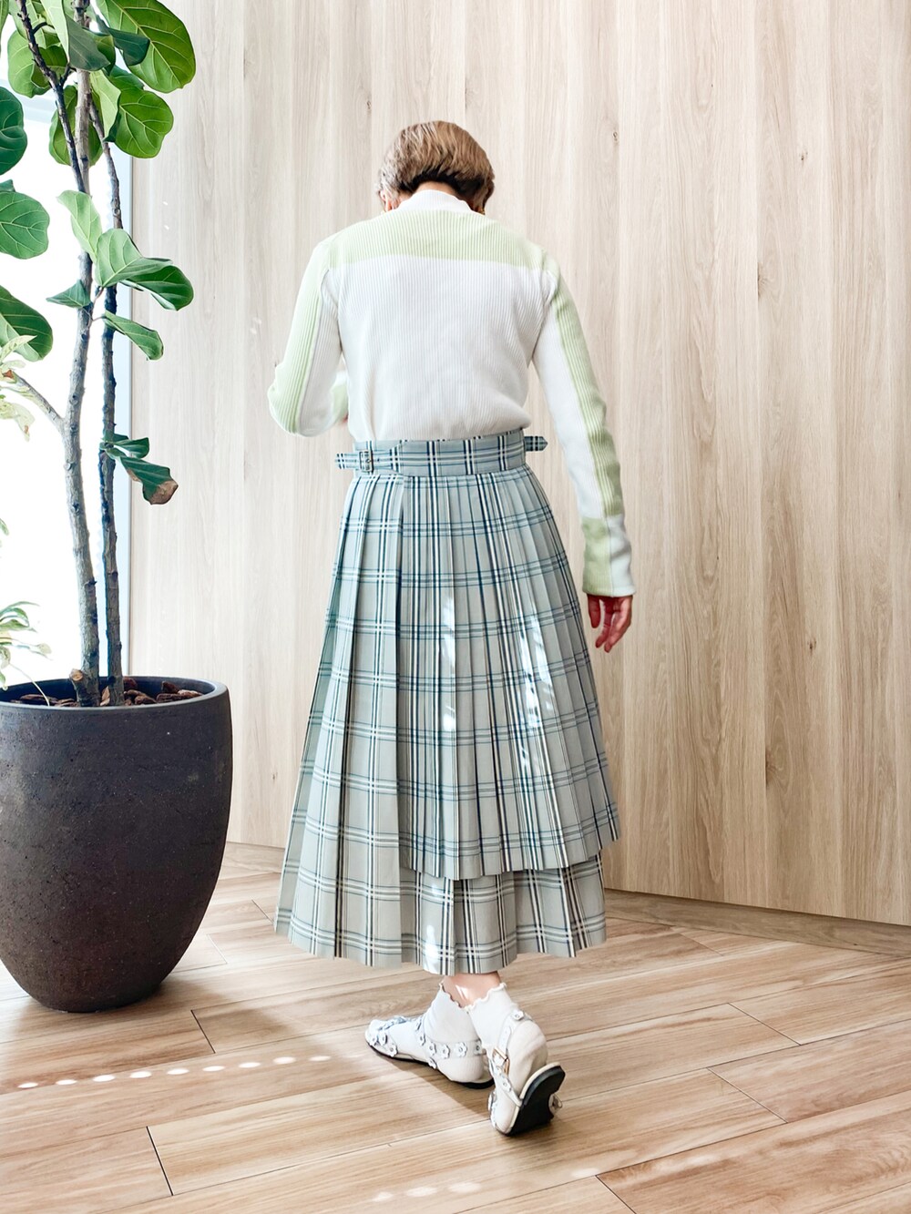 ホワイト系のサンダル、ホワイト系のニット/セーター、グリーン系のスカートを着用したレディースの秋コーディネートの3枚目の写真
