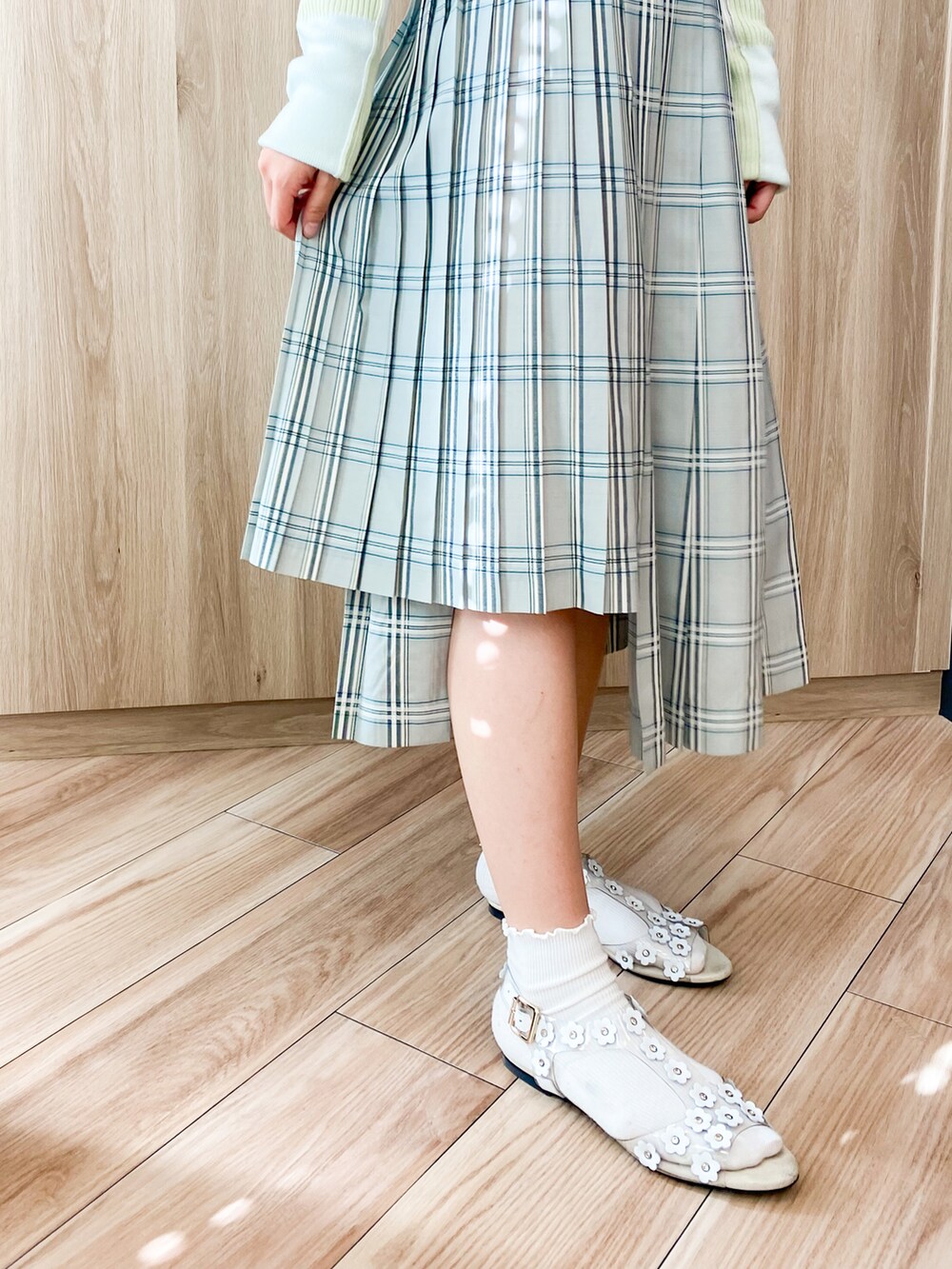 ホワイト系のサンダル、ホワイト系のニット/セーター、グリーン系のスカートを着用したレディースの秋コーディネートの4枚目の写真