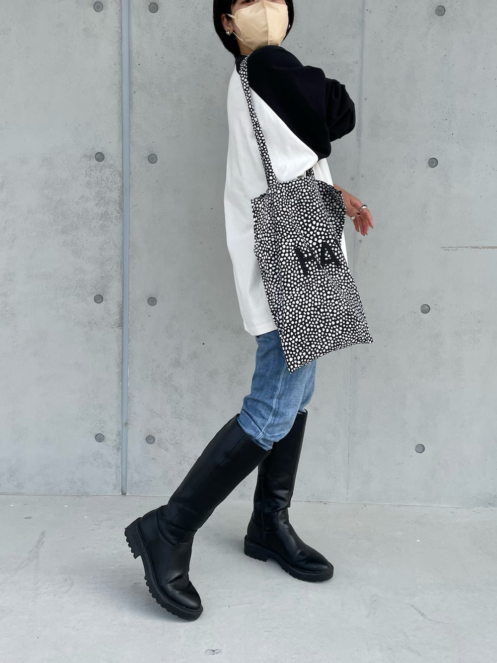 ブラック系のブーツ、ブラック系のトートバッグ、ブラック系のTシャツ/カットソーを着用したレディースの秋コーディネートの2枚目の写真
