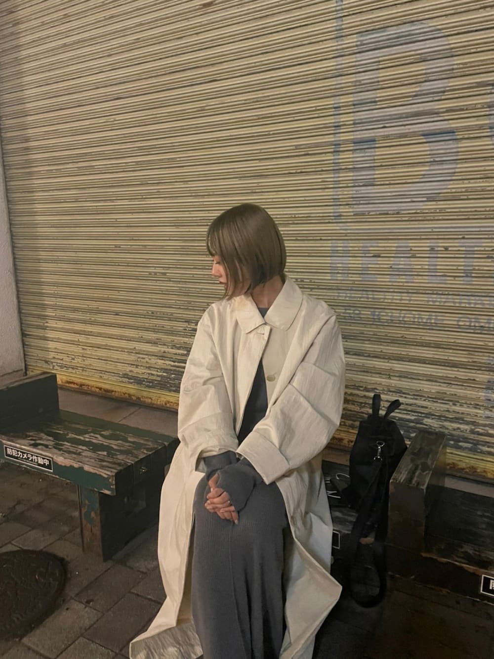 グレー系のワンピース、ホワイト系のステンカラーコートを着用したレディースの秋コーディネートの2枚目の写真