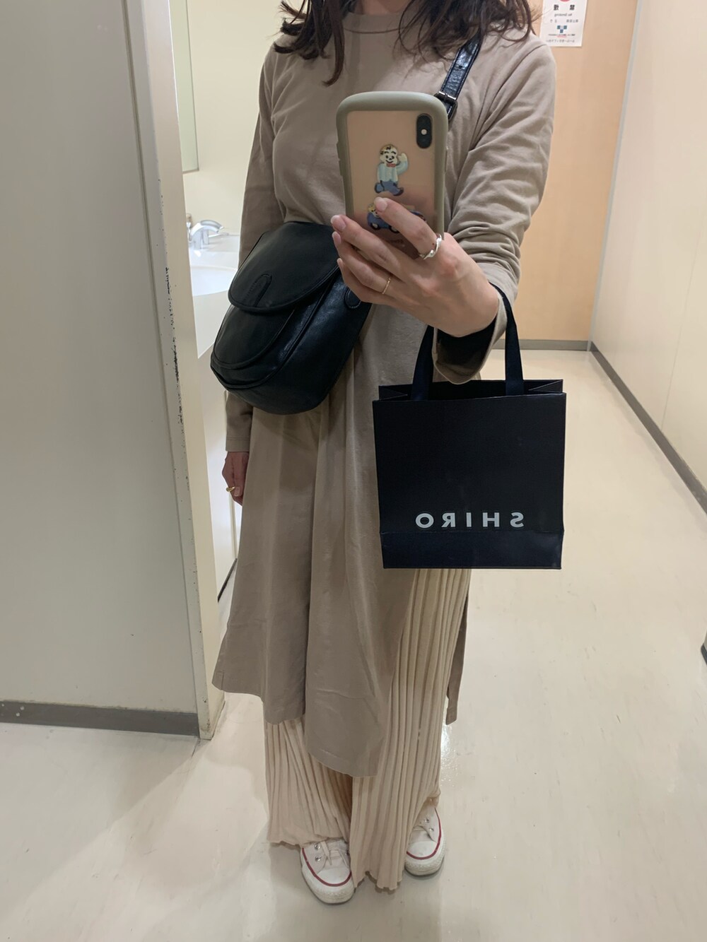 ホワイト系のスニーカー、ベージュ系のワンピース、ブラック系のその他パンツを着用したレディースの秋コーディネートの2枚目の写真