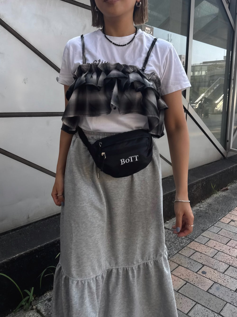 グレー系のスカート、ブラック系のキャミソール、ホワイト系のTシャツ/カットソーを着用したレディースの夏コーディネートの5枚目の写真