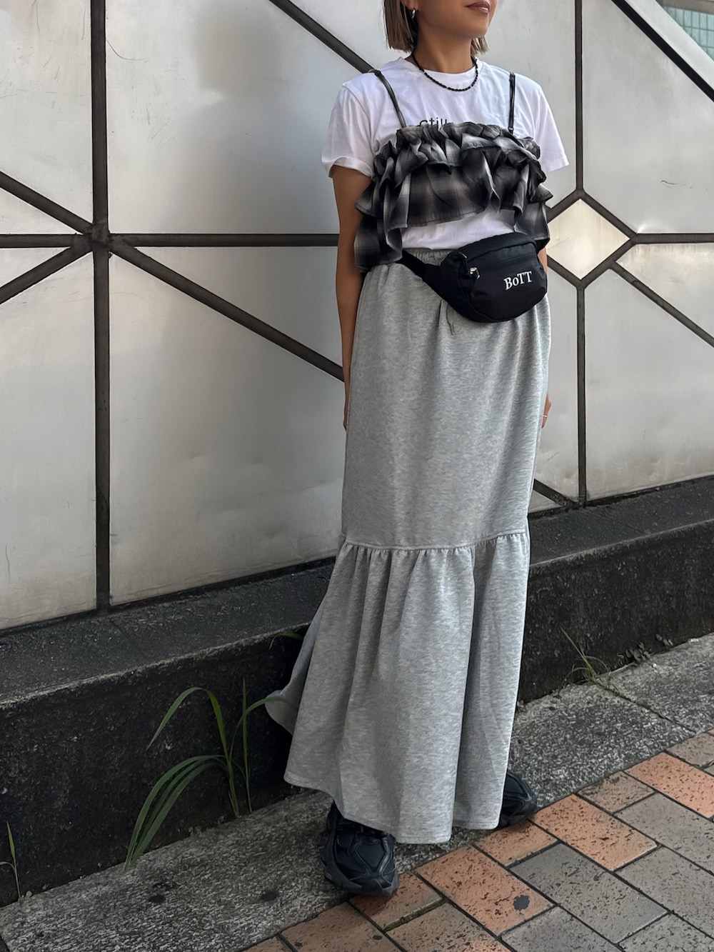 グレー系のスカート、ブラック系のキャミソール、ホワイト系のTシャツ/カットソーを着用したレディースの夏コーディネートの2枚目の写真
