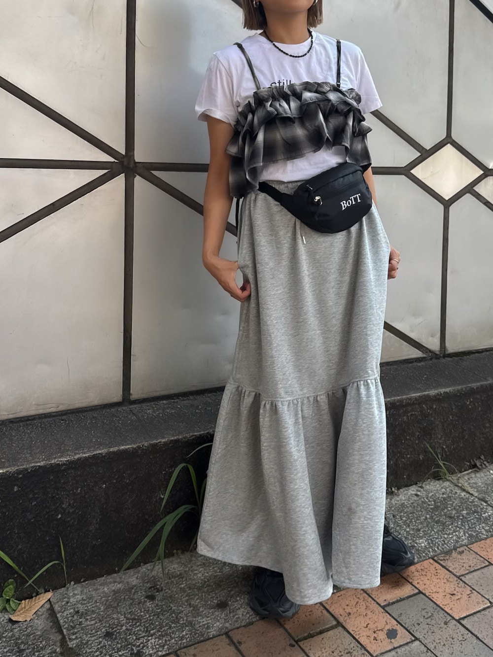 グレー系のスカート、ブラック系のキャミソール、ホワイト系のTシャツ/カットソーを着用したレディースの夏コーディネートの3枚目の写真