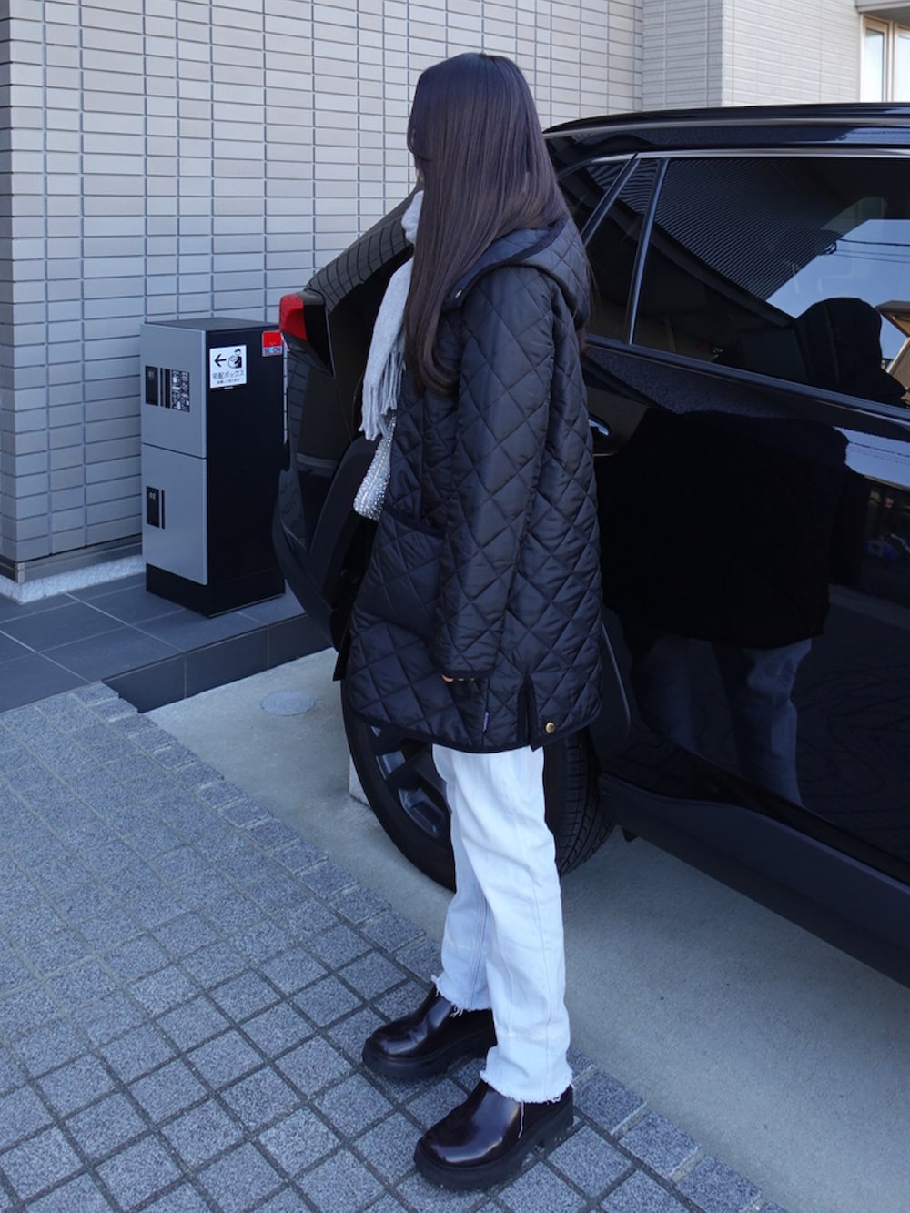 シルバー系のバッグ、ブラック系のジャケット/アウター、レッド系のブーツを着用したレディースの冬コーディネートの2枚目の写真