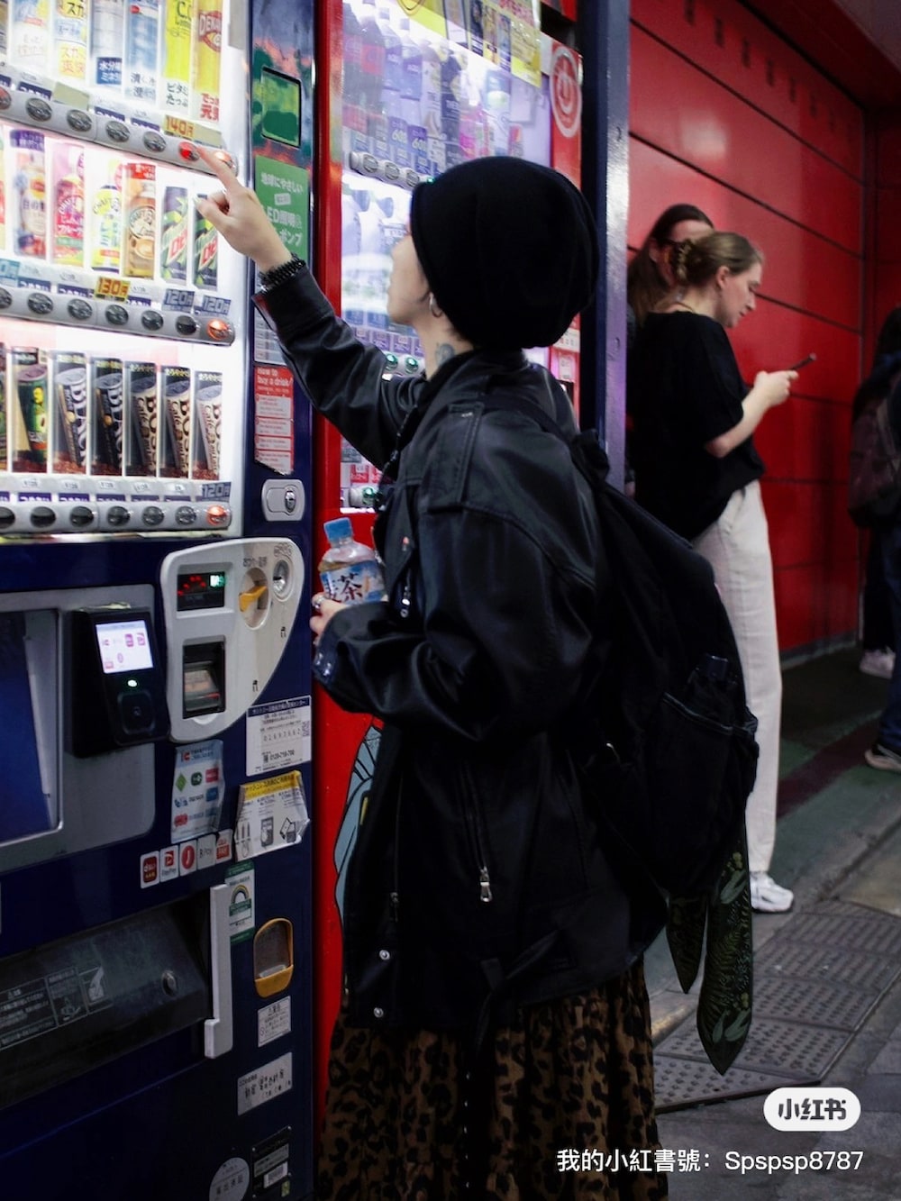 ブラック系のムートンコートを着用したレディースの春コーディネートの3枚目の写真