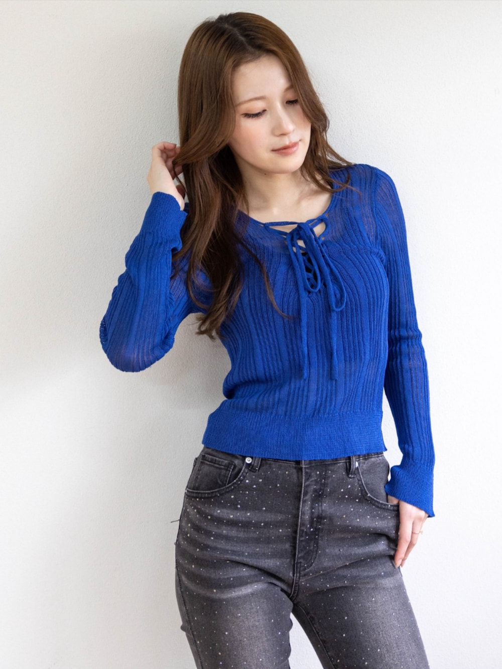 シルバー系のパンプス、ブラック系のデニムパンツ、ブルー系のニット/セーターを着用したレディースの春コーディネートの3枚目の写真