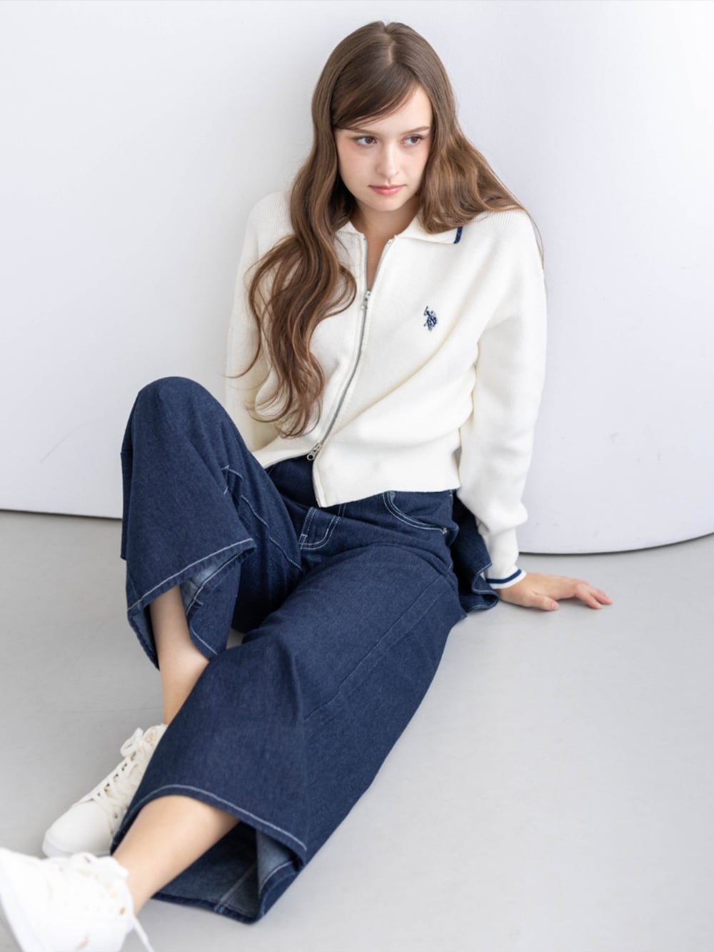 ゴールド系のスニーカー、ブルー系のデニムパンツ、ホワイト系のTシャツ/カットソーを着用したレディースの秋コーディネートの6枚目の写真