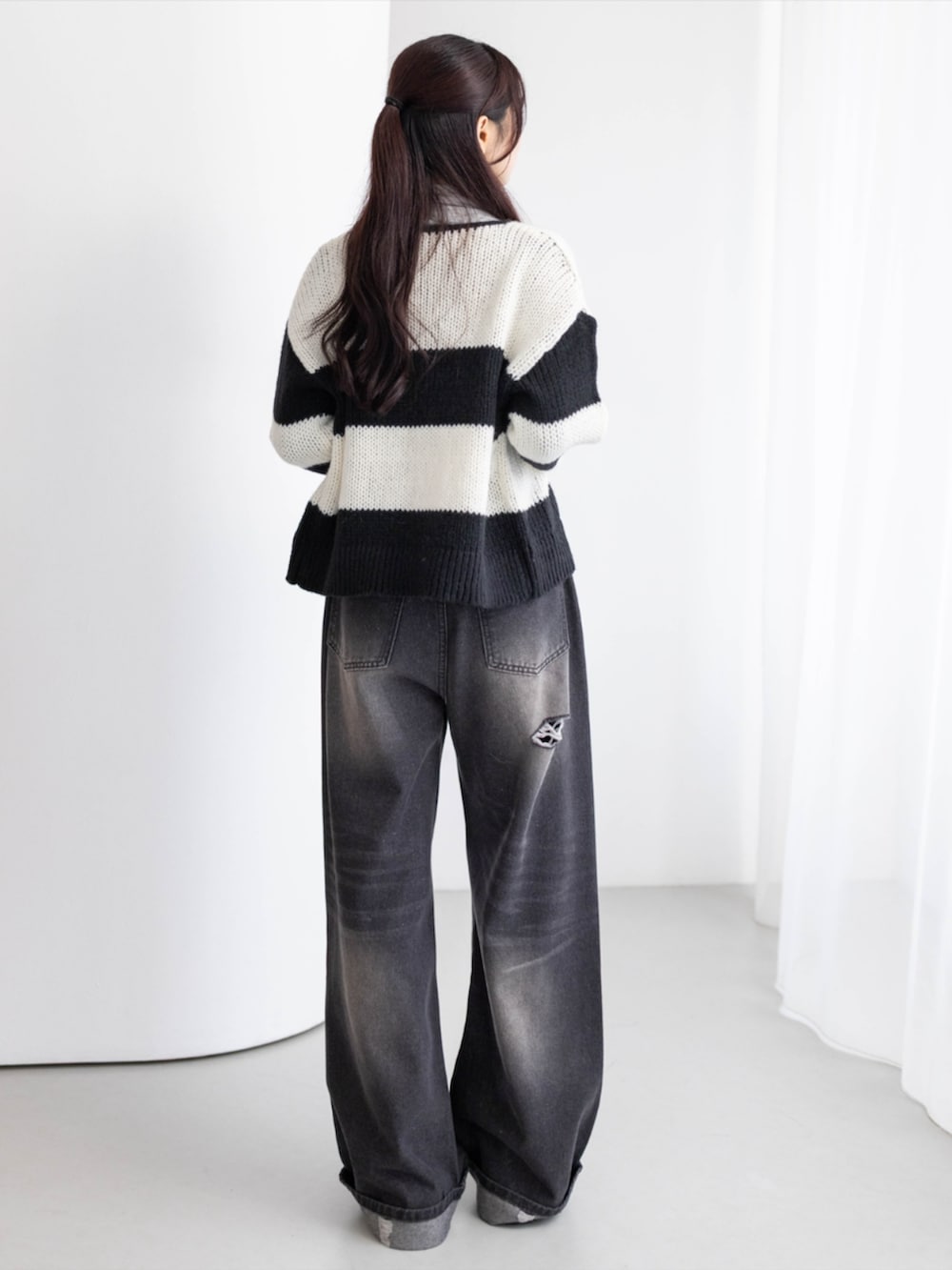 グレー系のTシャツ/カットソー、ブラック系のデニムパンツ、ブラック系のブーツを着用したレディースの秋コーディネートの3枚目の写真