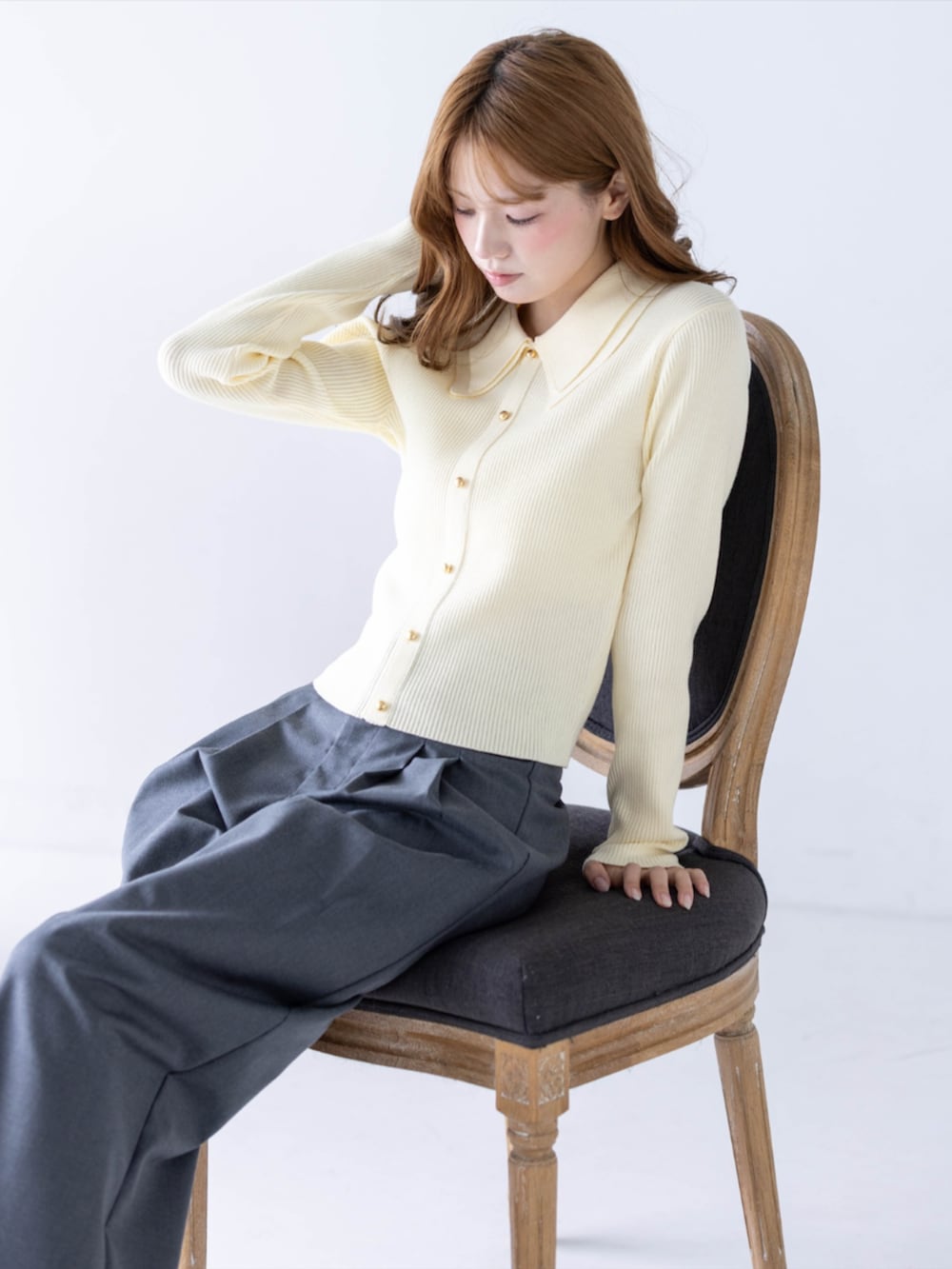 グレー系のスラックス、ブラック系のパンプス、イエロー系のニット/セーターを着用したレディースの秋コーディネートの4枚目の写真