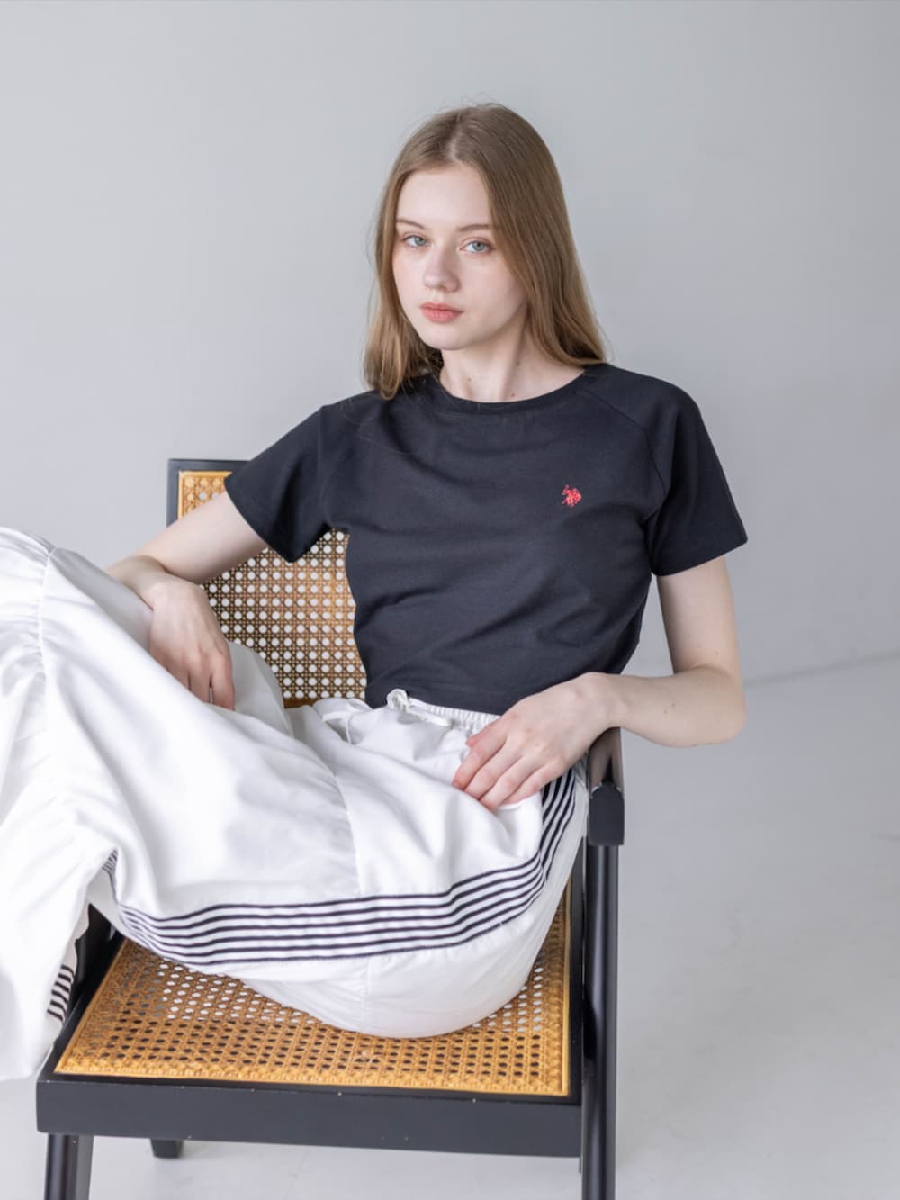 ブラック系のスニーカー、ホワイト系のスカート、ブラック系のTシャツ/カットソーを着用したレディースの夏コーディネートの9枚目の写真