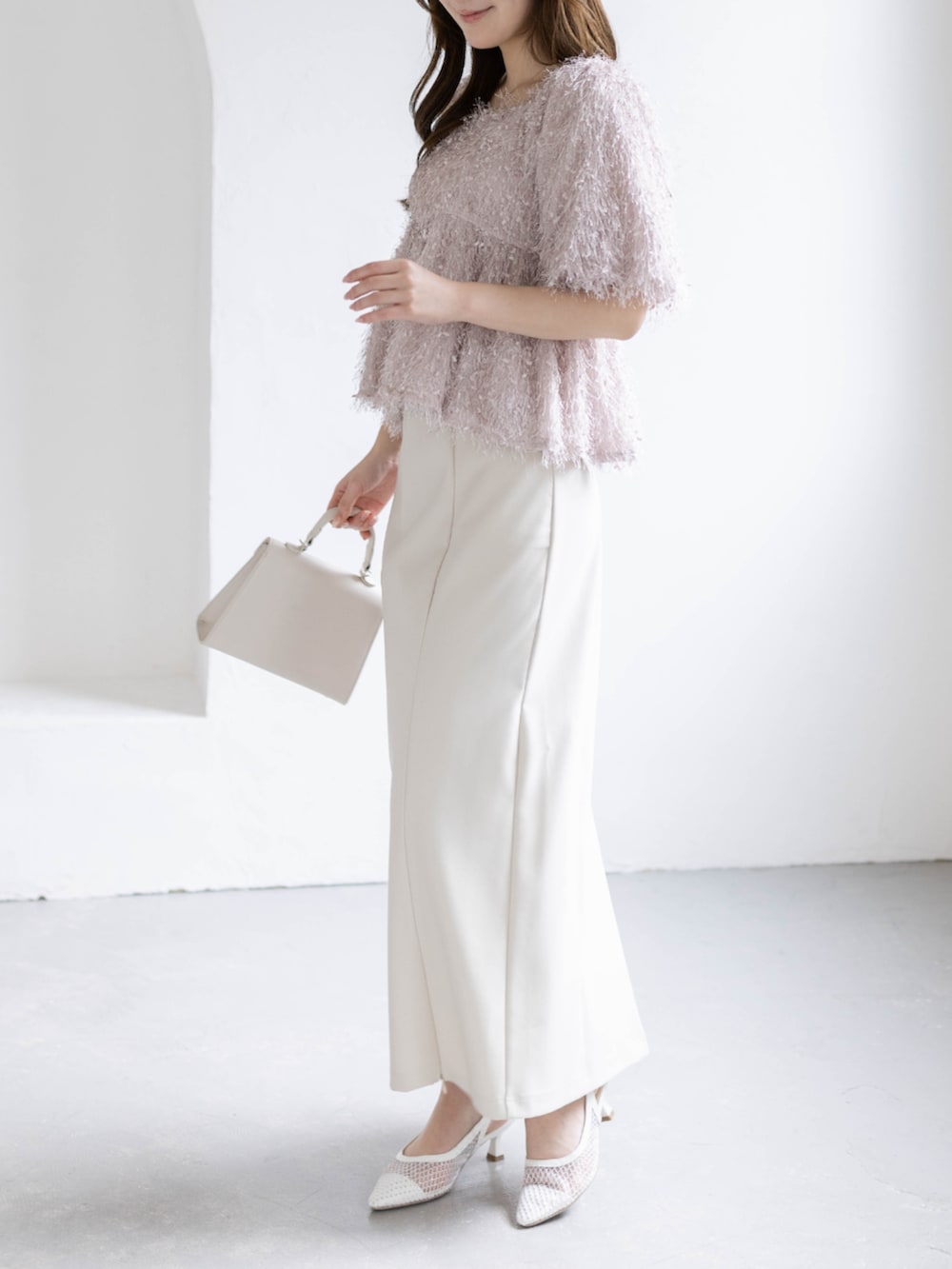 ホワイト系のスカート、ホワイト系のハンドバッグ、ホワイト系のパンプスを着用したレディースの春コーディネートの5枚目の写真