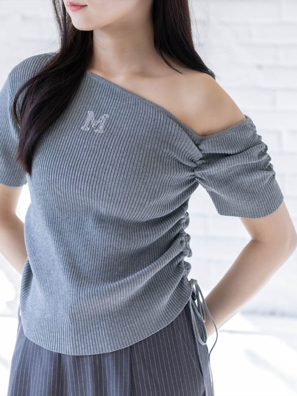 ホワイト系のスニーカー、グレー系のスラックス、グレー系のニット/セーターを着用したレディースの春コーディネートの4枚目の写真