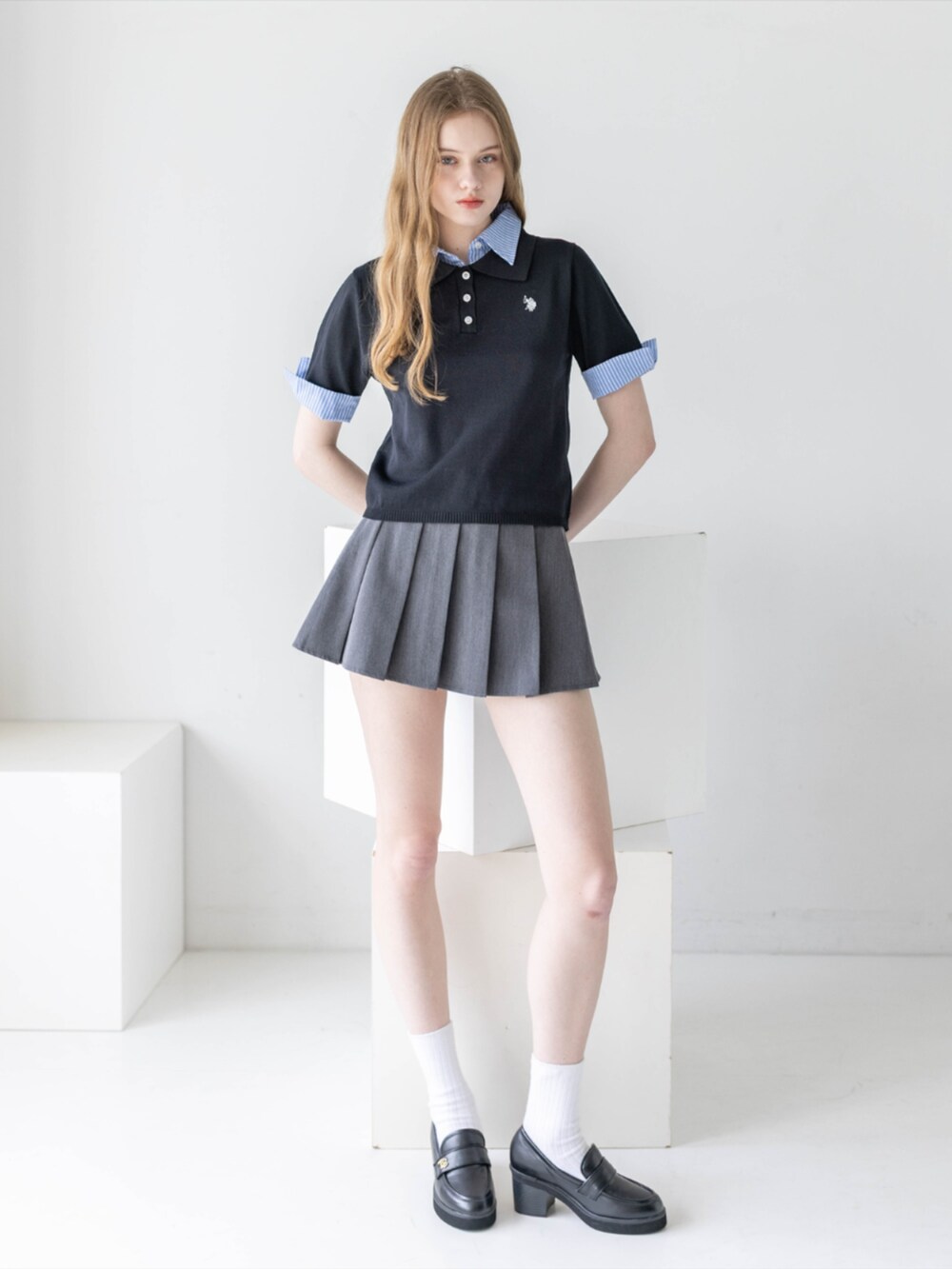 ブラック系のローファー、グレー系のスカート、ブラック系のニット/セーターを着用したレディースの夏コーディネートの3枚目の写真