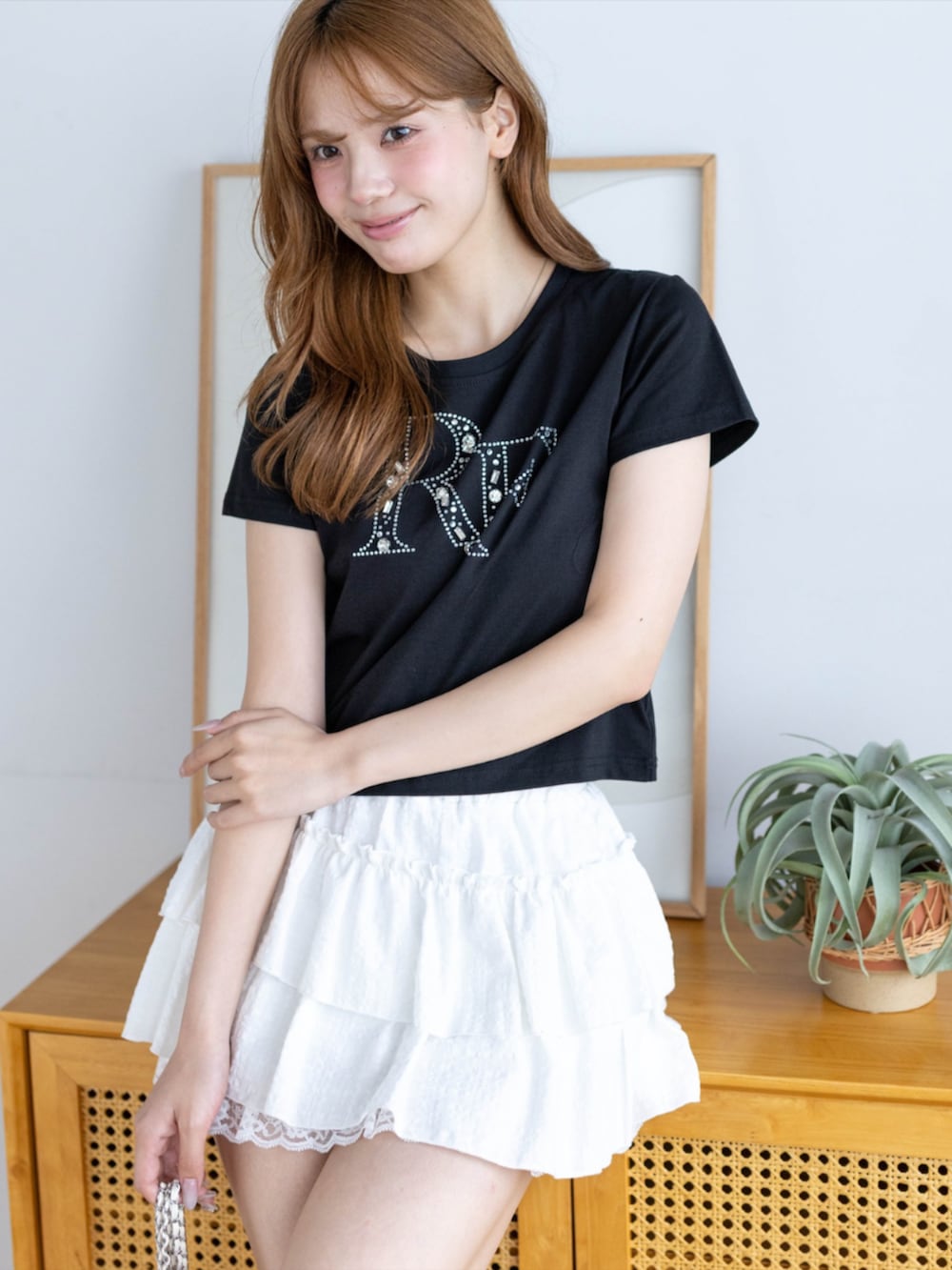 ホワイト系のスカート、ブラック系のTシャツ/カットソーを着用したレディースの夏コーディネートの3枚目の写真