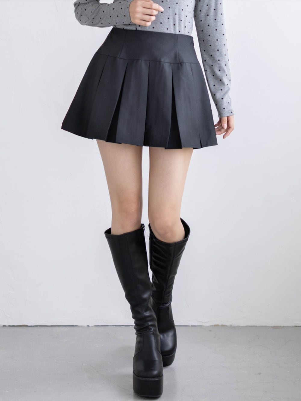 ブラック系のブーツ、ブラック系のスカート、グレー系のTシャツ/カットソーを着用したレディースの秋コーディネートの5枚目の写真
