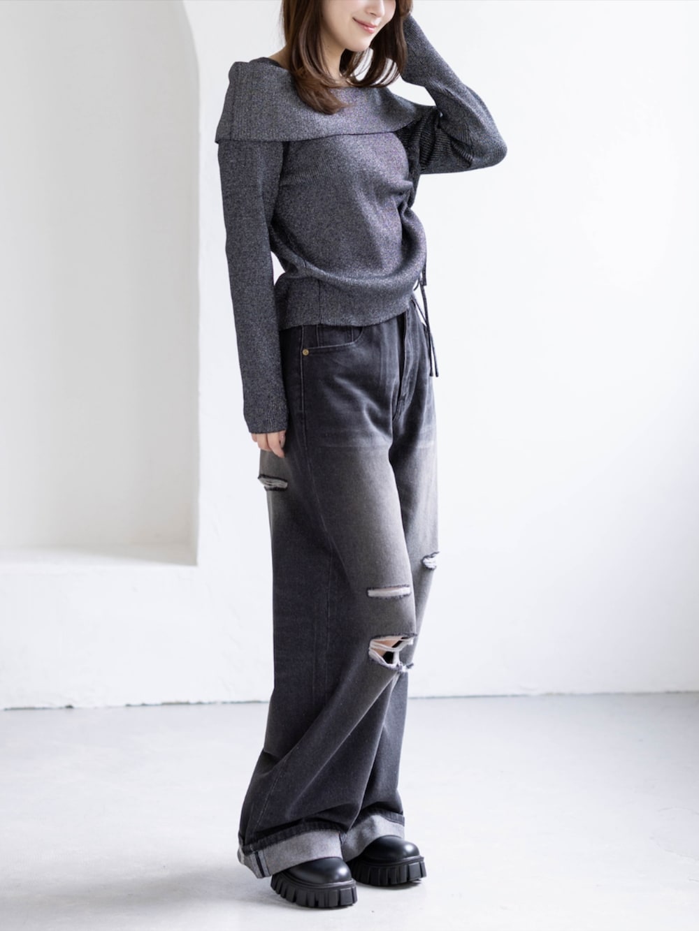 ブラック系のデニムパンツ、ブラック系のブーツ、ブラック系のニット/セーターを着用したレディースの秋コーディネートの3枚目の写真