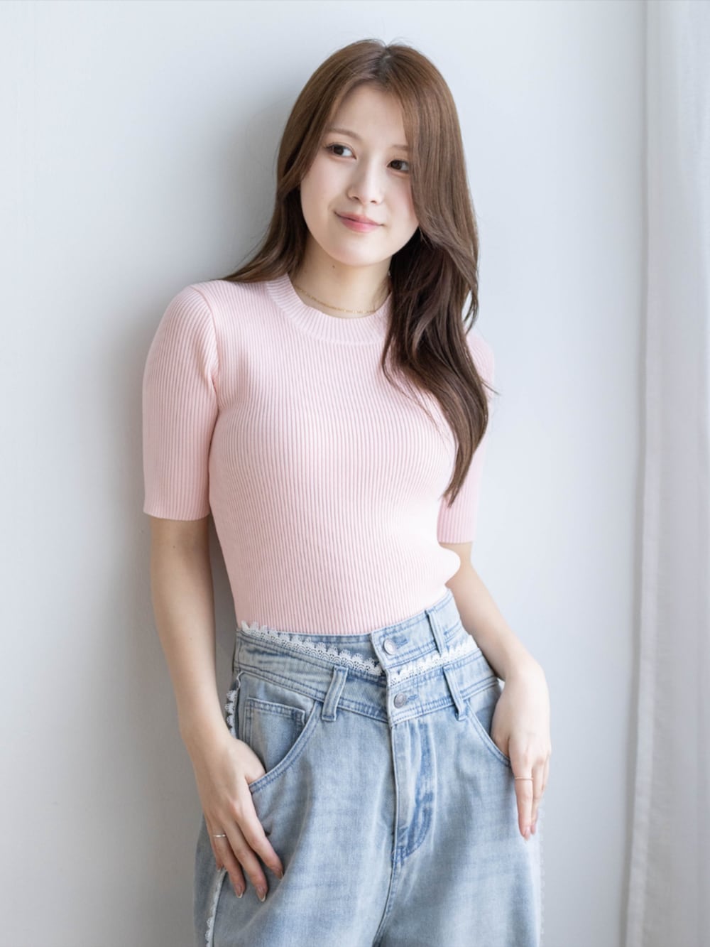ピンク系のニット/セーター、ブルー系のデニムパンツ、ホワイト系のパンプスを着用したレディースの夏コーディネートの3枚目の写真